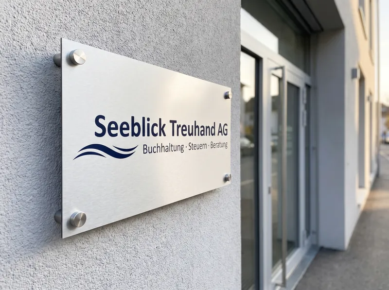 Firmenschild aus gebürstetem Alu-Dibond mit Edelstahl-Abstandhaltern an einer verputzten Hausfassade neben dem Eingang